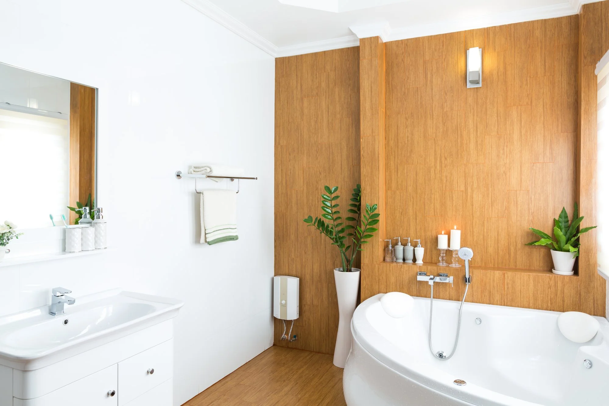 Bright bathroom with a white vanity, corner bathtub and warm wood wall panel
