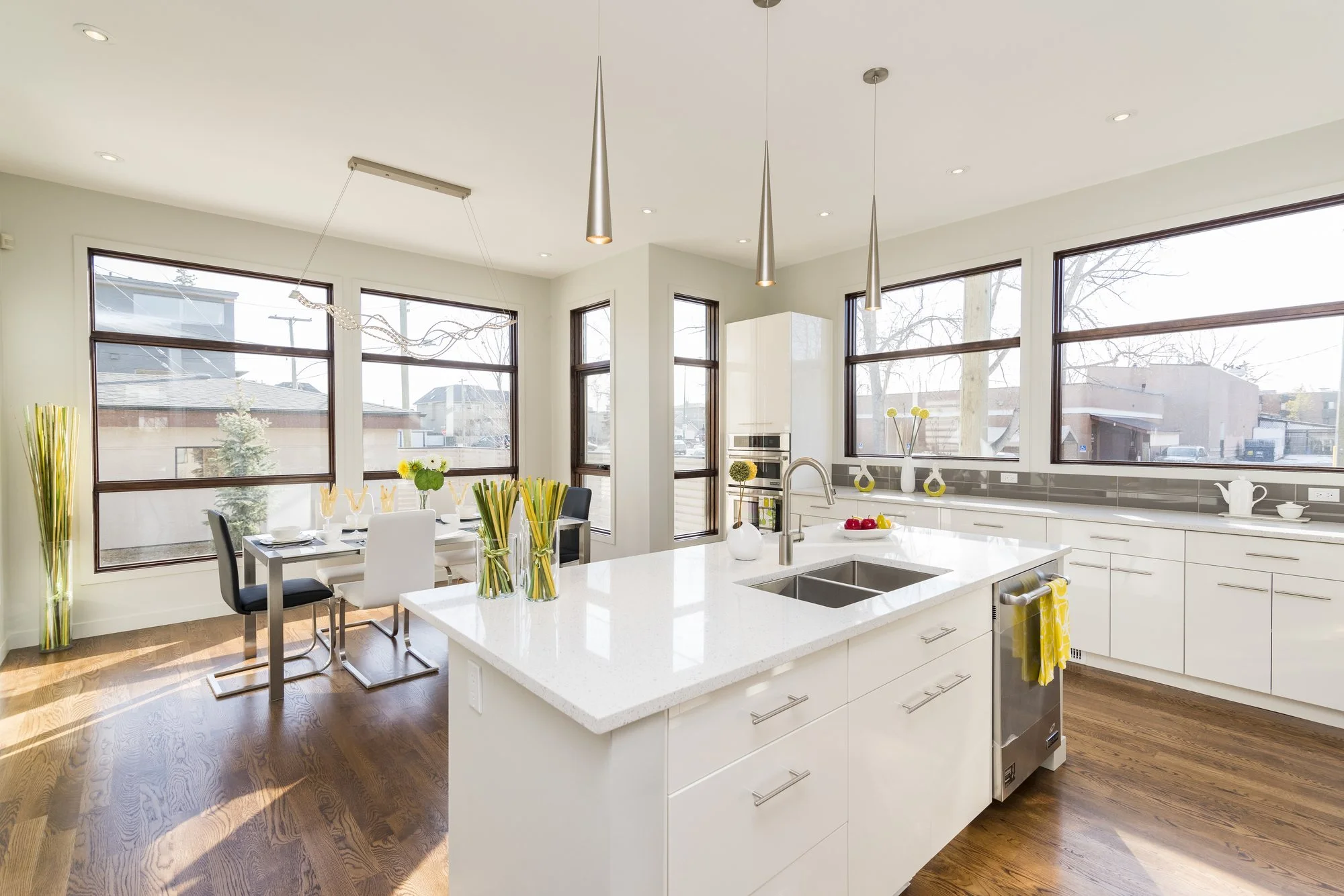 Modern kitchen with a white island, black-framed windows and pendant lights